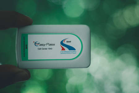 Samut Prakan, Thailand - April 25 2020 : Hand holding of new card for Electronic toll collection (ETC) aims to eliminate the delay on toll roads by collecting tolls electronically. Traffic on Motorway Easy Pass in Thailandのeditorial素材