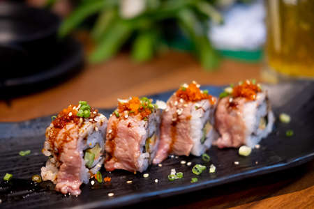 Wagyu beef sushi rolls on black dish. Close up