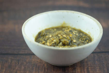 Nam Prik Num (Northern Thai Green Chilli Dip) on wood table. Thai Lanna food