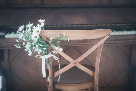 Wood chair piano decoration with flowerの写真素材