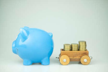 Blue piggy bank and stock of gold coins. Money concept.の写真素材