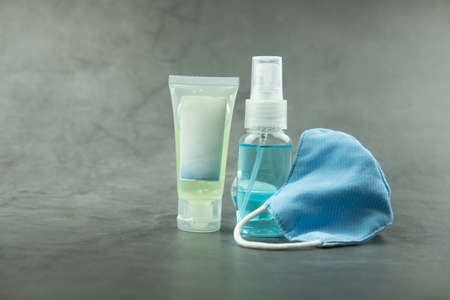 Close up blue fabric mask with hand gel and alcohol spray. Prevention coronavirus through bacteria.の写真素材