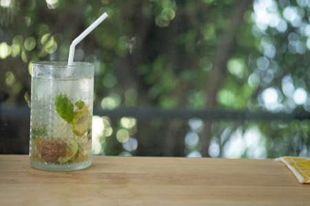 Iced plum juice mixed with lemon and soda on wooden table. The perfect summer drink.の写真素材
