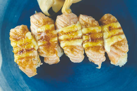 Salmon burned sushi with cheese on blue dish. Japanese food styleの写真素材
