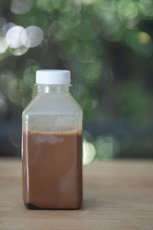 Mini coffee bottle with plastic cover on wood table. The concept of inviting people to buy takeaway during virus diseases outbreak COVID-19 pandemic .の写真素材