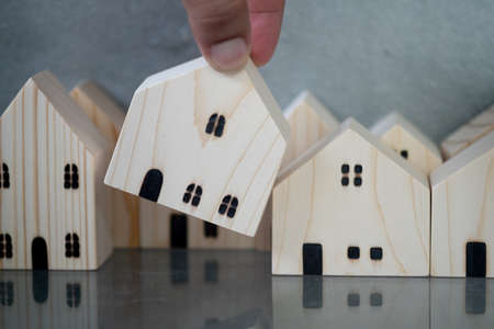 Hand choosing house. Choose what's the best. Concept of planning to buy property.