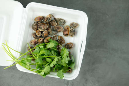 Fresh and delicious boiledâ cocklesâ shell eating with spicy seafood sauce and fresh vegetable put in foam box. Thai food.の写真素材