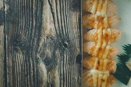 Burn salmon sushi in box on wood table. Selective focusの写真素材