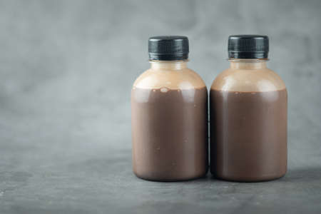 Two plastic bottle of tasty cocoa milk on a black backgroundの写真素材