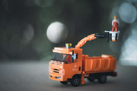 Miniature electrician on picker car crane. Concept of electrician worker repair or reinstall traffic lights. Car crane industry equipmentの写真素材