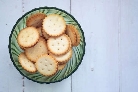 Crackers with pineapple jam in green glass bowl on wood tableの写真素材