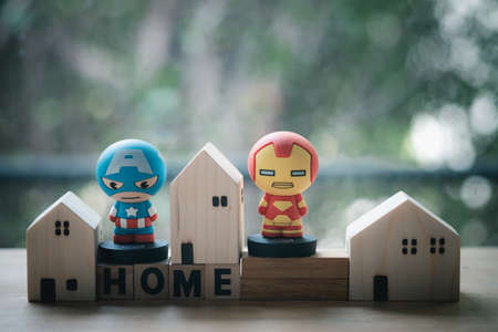 Bangkok, Thailand - June 7, 2020: Superhero with miniature wood home. Concept of hero at home. Concept of stay home to reduce risk of infection and spreading the virus. Stay safe, stay inside home.のeditorial素材