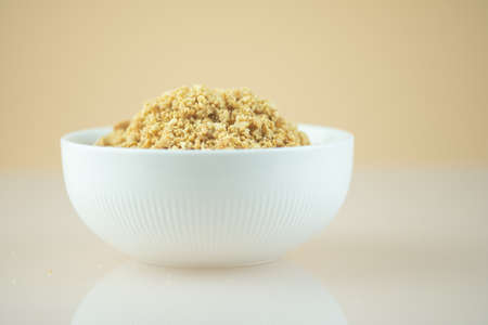 Bowl of roasted crushed peanuts or crush peanuts on white background.