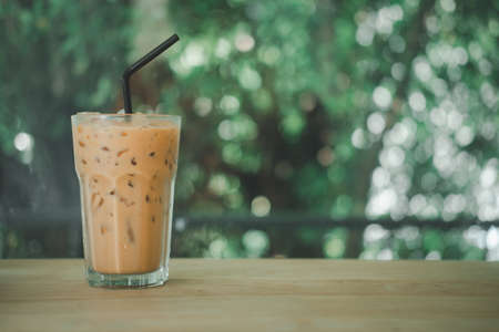 Close up iced espresso coffee in tall shaped glass on wood tableの写真素材