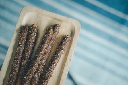 Almond and chocolate biscuit stick on wooden tray