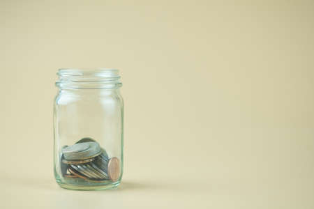 Close up of Thai coins in glass jar. Saving money concept with copy space.の写真素材