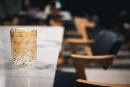 Whiskey in a crystal glass with ice cubes on table dinnerの写真素材