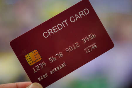 Close up photography of hand man holding a red credit cardの写真素材