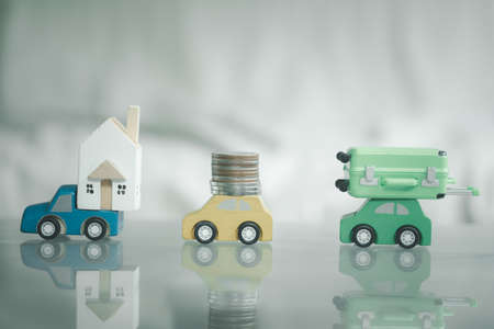 Miniature wood toy car load, home, coin and suitcase. Concept of lifeの写真素材
