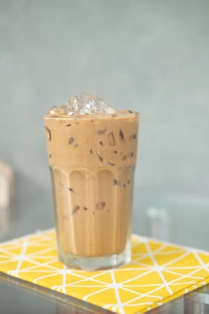 Glass of iced coffee on the table in a coffee shopの写真素材