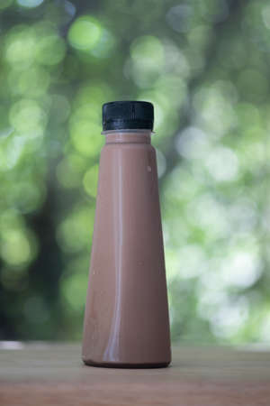 Iced cocoa in a plastic bottle on wooden tableの写真素材