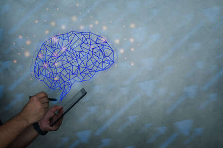 Brain representing artificial intelligence and businessman holding futuristic tablet. Data mining and another modern computer technologies concepts.の写真素材