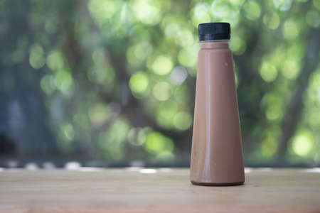 Iced cocoa in a plastic bottle on wooden tableの写真素材