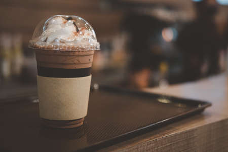 Closeup of takeaway plastic cup of iced cocoa with whipped cream on top.の写真素材