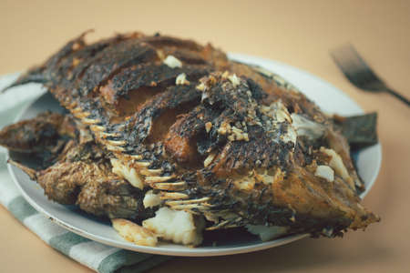 Deep fried Tilapia fish after fried on dish ready to eat. Concept of Thai style homemade food