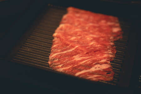 Fresh raw pork beef slice for grill serving on black tray. Thin slices of pork beef.の写真素材