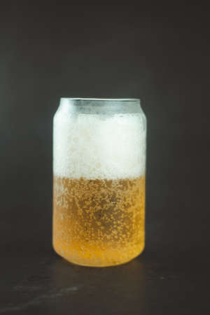 Close up of cold beer with foam on dark background