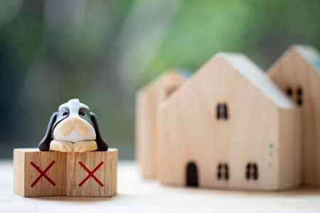 Toy dog on wood block red X. Concept of do not bring pets on the inside. Symbols of restaurant concept.の写真素材