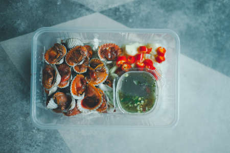 Steamed cockle (Boiled cockles) with spicy seafood sauce in transparent box. Thai style foodの写真素材