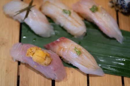Plate of various pieces of fish sushi on wooden tray in Japan restaurants
