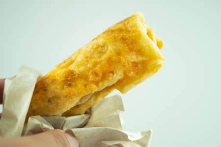 Hand holding roti wrap a crispy fried dough with sugar and sweet condensed milk. Popular and tasty...