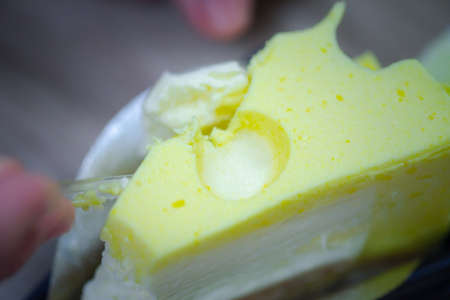 Eating tasty yellow cheesecake with spoon. Concept of enjoy eatingの写真素材