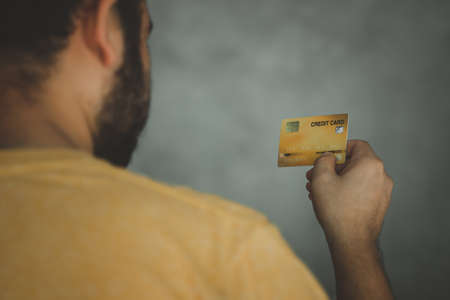Cropped view of beard man holding yellow credit card, back viewの写真素材