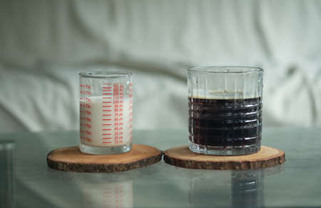 Hot black coffee in glass with fresh milk in shot glass. Refreshment drink beverage