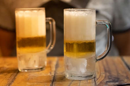 Jugs of beer placed on wooden bar. Close upの写真素材