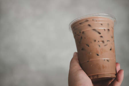 Man holding plastic glass of iced Mocha coffee with copy spaceの写真素材
