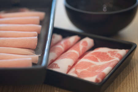 Thin of fresh streaky pork in black tray for hot pot ready to cookの写真素材