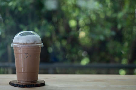 Iced coffee or mocha in take away cup on wood saucerの写真素材