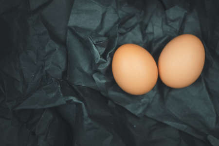 Raw of fresh chicken eggs on a black paper backgroundの写真素材