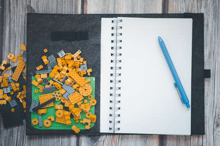 Pen put on empty notebook and plastic blocks. Leisure and hobbies of the child. Copy spaceの写真素材