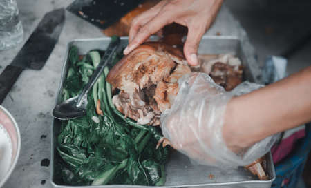 Thai chef slice braised pork leg or stewed pork leg, popular street foods in Thailand. Thai foodの写真素材