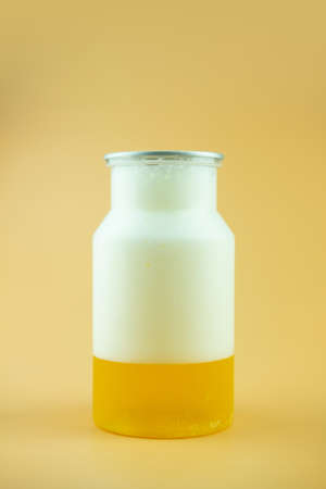 Glass of full freshly beer with foam on yellow background. Close upの写真素材