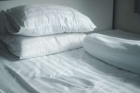 Close up white pillow and bolster on white bed in homeの写真素材