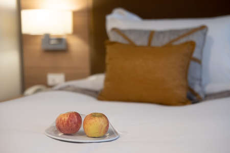 Welcome fruit, red apple put on white bed ready to eat in the hotel bedroomの写真素材