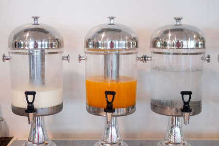 Hotel beverages dispensers. Drinking water, fresh milk and orange juice for guests of seminar for...