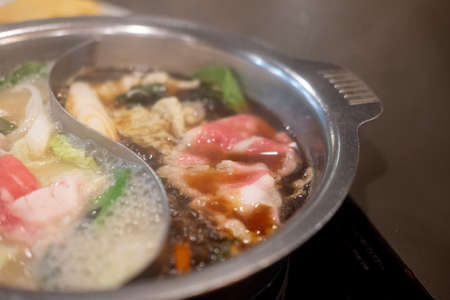 Boiling pork and beef with two soup favor in specially made pot for two soupの写真素材